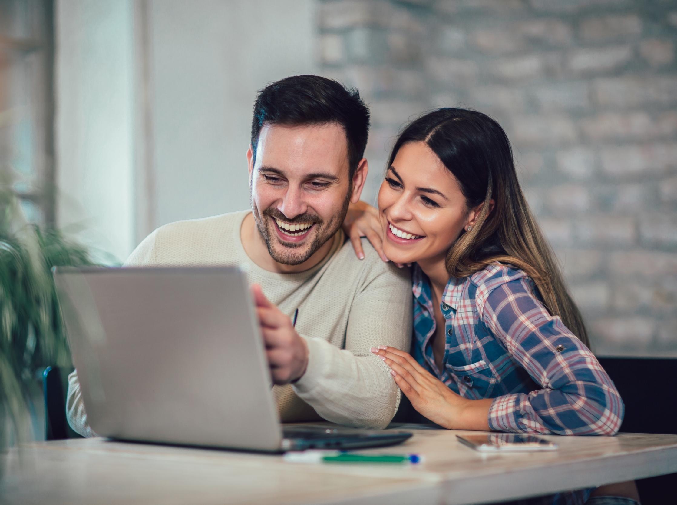 Smiling couple using laptop